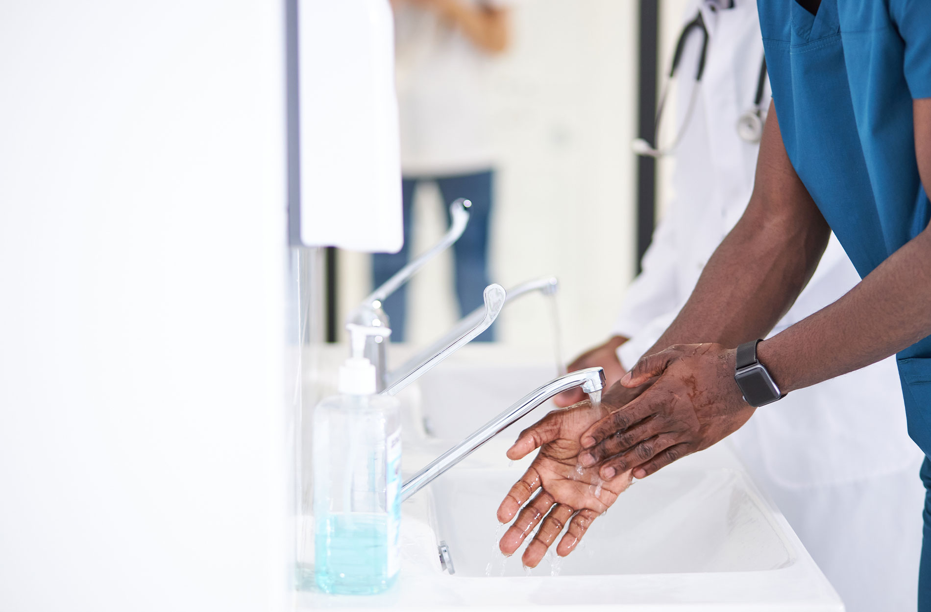 African Doctor washing hands properly with soap to be protected during work in hospital.